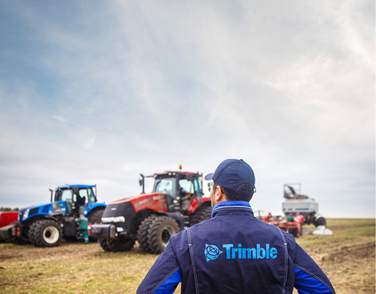 Un distribuidor autorizado de Trimble mira hacia los tractores de sus clientes.