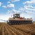 Un agricultor siembra un campo utilizando el sistema de dirección Trimble Autopilot y la funcionalidad ISOBUS.