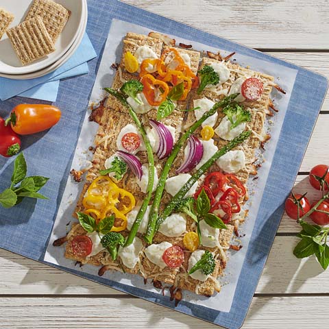 Artisan vegetable pizza with fresh veggies and cheese, a delightful springtime appetizer
