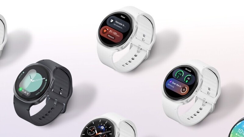Flera Samsung Galaxy Watch 8-smartklockor i vitt och mörkgrått ligger utplacerade på en vit yta. Klockornas skärmar är påslagna och visar olika appar. Klockorna har runda boetter och släta armband. 