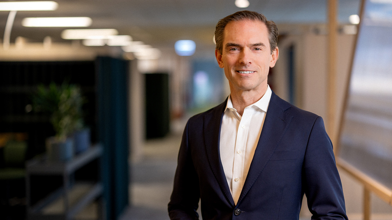 Nicholas Högberg, kommersiell chef på Tele2, stående i kontorslandskap. 