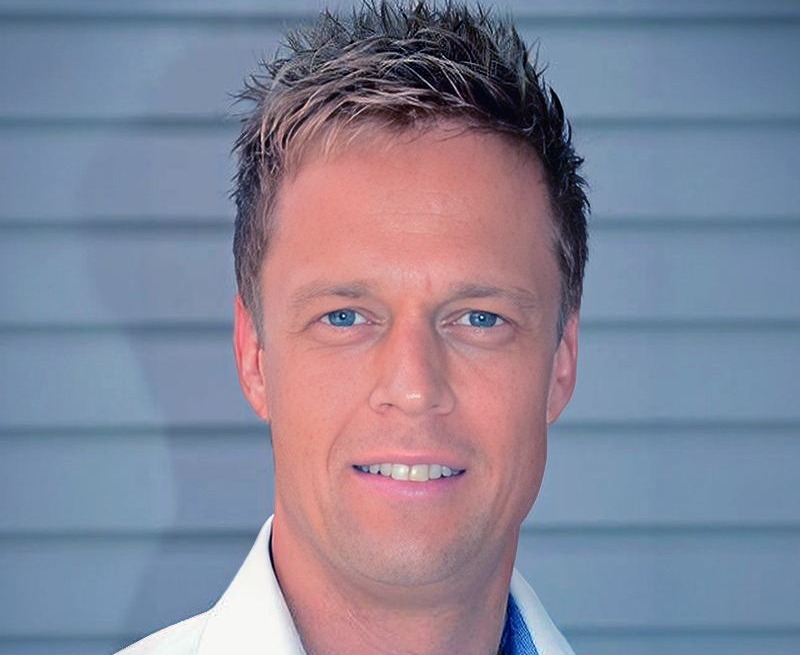 Magnus Bureteg, Key Account Manager på Tele2 Företag. Han är blond med kort hår och blå ögon. Han är klädd i vit skjorta och ler. Bakom honom syns en grå husvägg. 