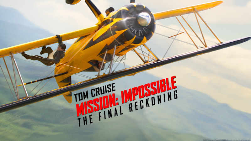 Gult dubbeldäckat flygplan i luften med filmtiteln "Mission: Impossible - The Final Reckoning" synlig i förgrunden.