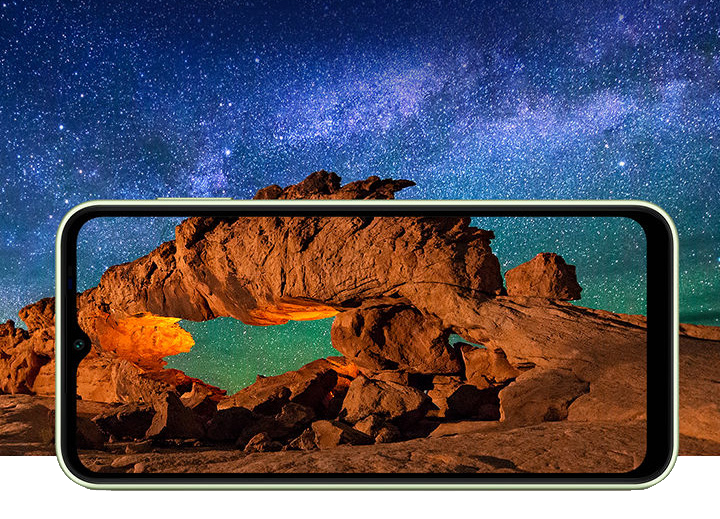 Samsung Galaxy A14 5G i förgrunden med lanskapsbild som bakgrund