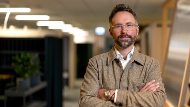 Erik Wottrich hållbarhetschef Tele2 stående i ett kontorslandskap. 