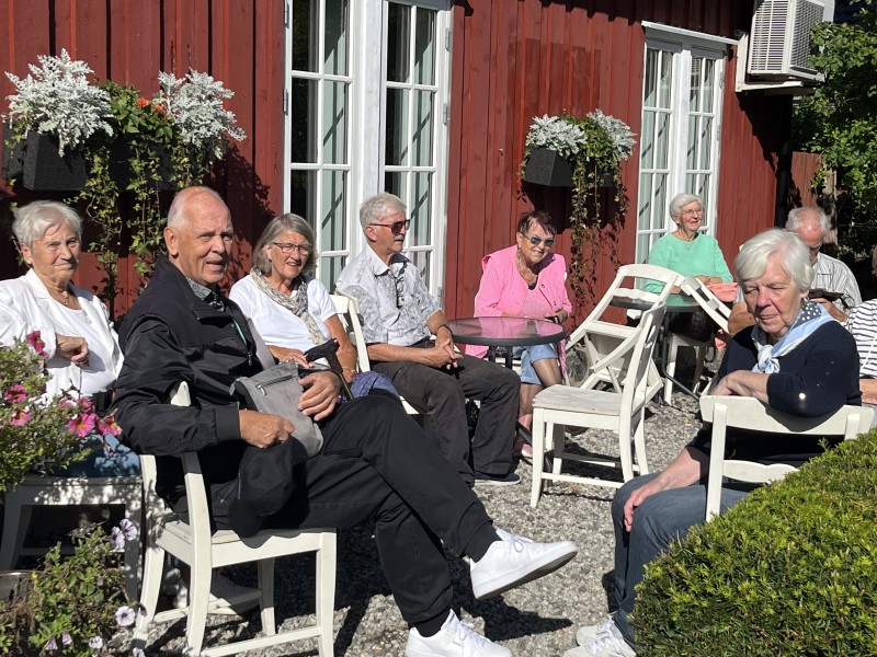 Her sitter både formann, kasser og sekretær i styret sammen med andre turdeltakere i solen  på Bjellandstrand gård.