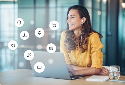 Una donna sorride mentre utilizza un computer portatile in un ufficio. Intorno a lei ci sono varie icone che indicano diverse funzioni e attività aziendali, come cuffie, carrello della spesa e schermo di presentazione.