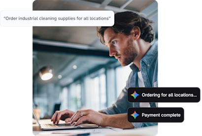 Man typing on a laptop with AI prompts signifying 'payment complete, and 'ordering for all locations'.