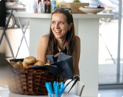 Picture of a women with glasses on top of her head laughing.