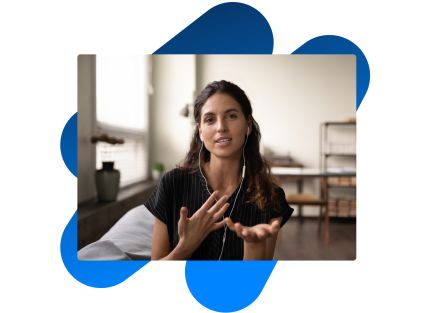 Dark haired woman with headphones explaining something to the camera