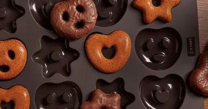 Silicone baking tray with pretzel and star shaped baked goods on a wooden table