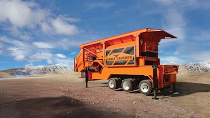 Orange machinery from Eagle Crusher in a works site surrounded by rocks