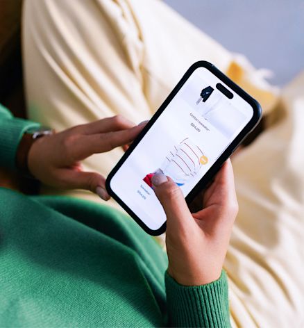Person holding a smartphone while browsing an online shop, seen from above.