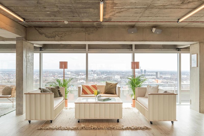 Bright office location with yellow desks and blue chairs.