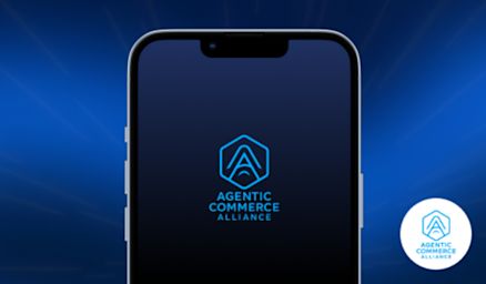 Mobile phone sits on a dark blue background, with the agentic commerce alliance logo center screen. 