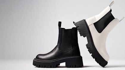 Zwei einzelne Schuhe, die vor einem Studiohintergrund aneinander liegen
