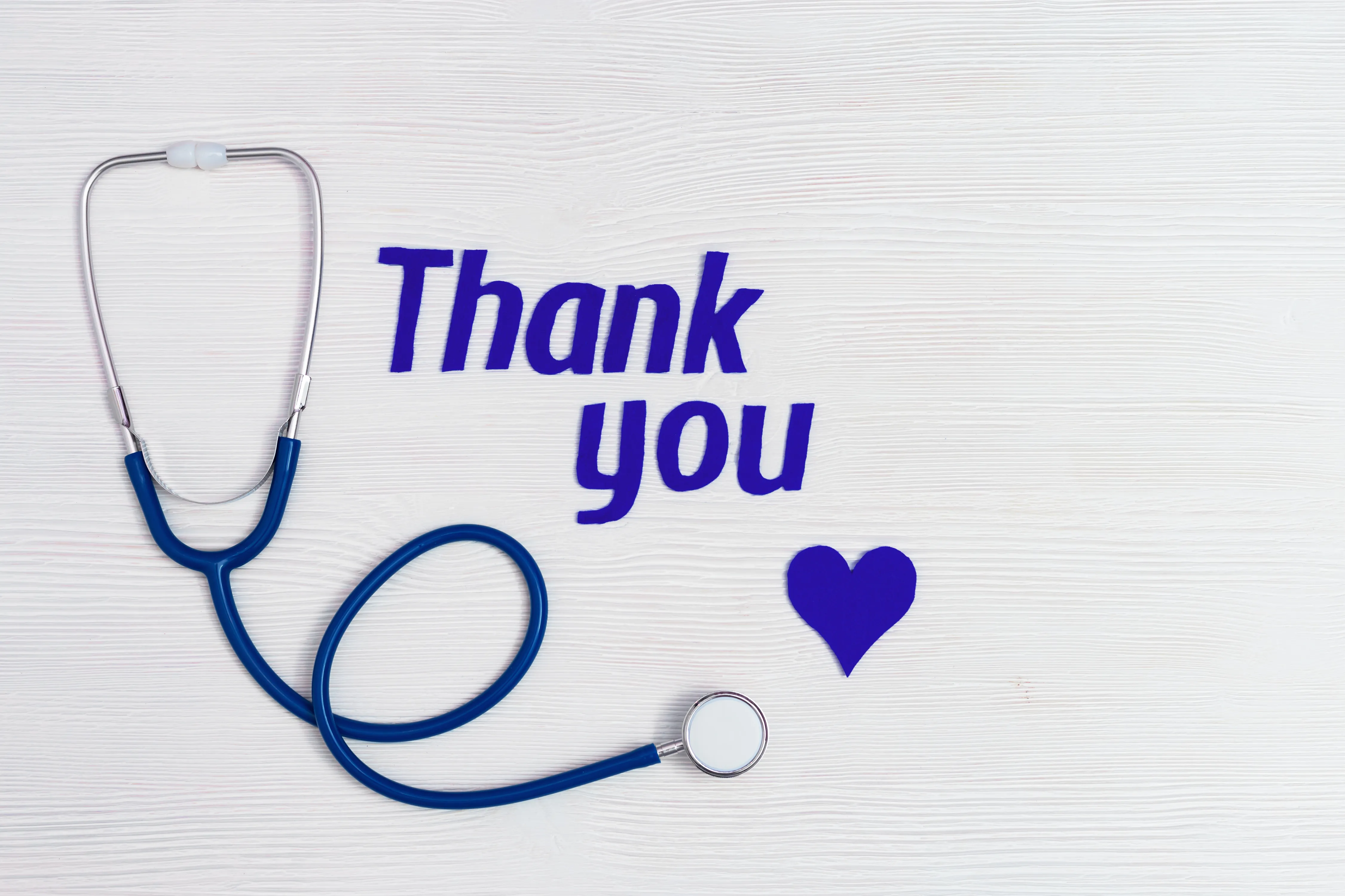 8614809-medical-stethoscope-blue-heart-text-thank-you-white-wooden-background-with-copy-space-healthcare-medicine-concept-national-nurses-day