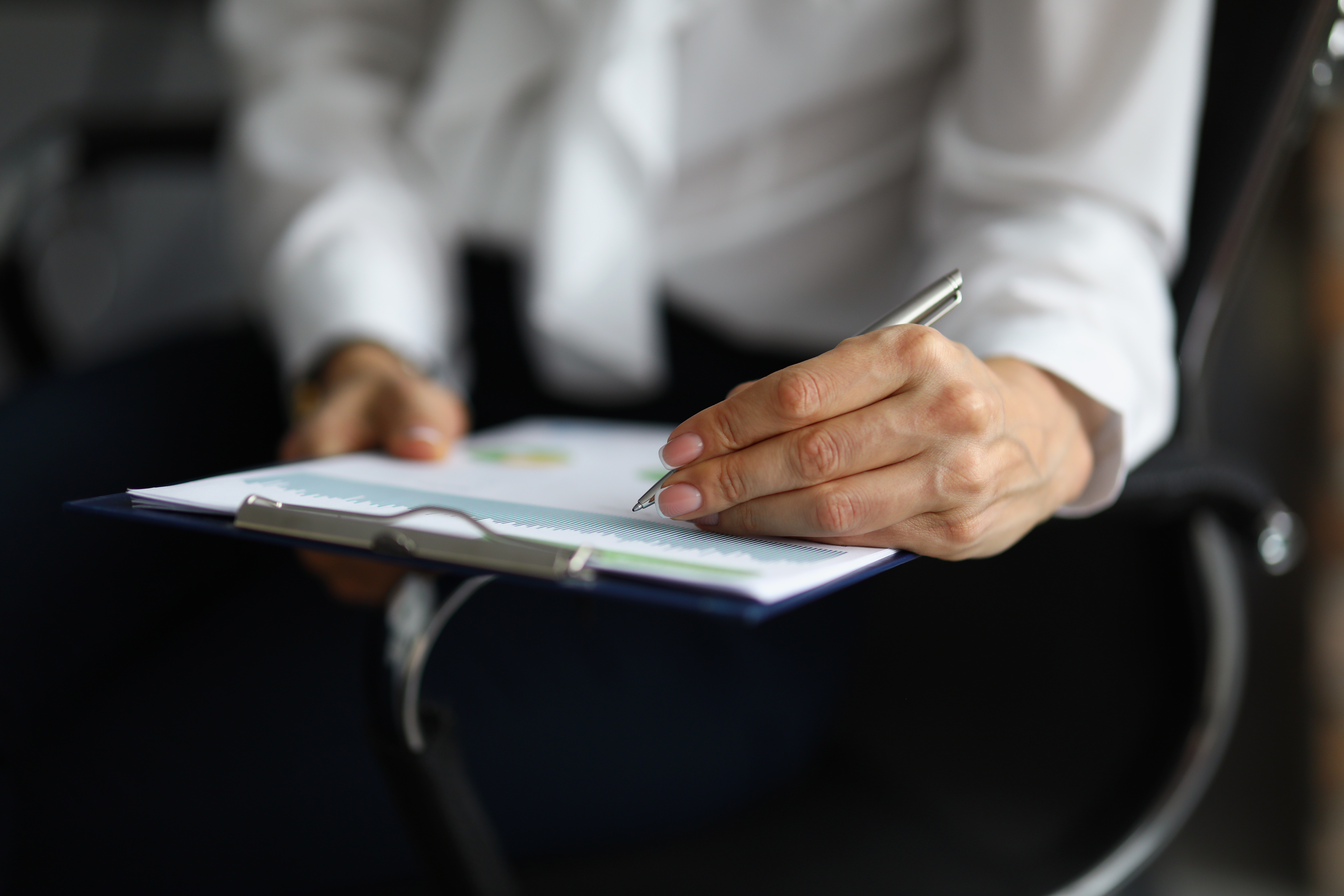 female-hand-holding-pen-put-signature-business-paper
