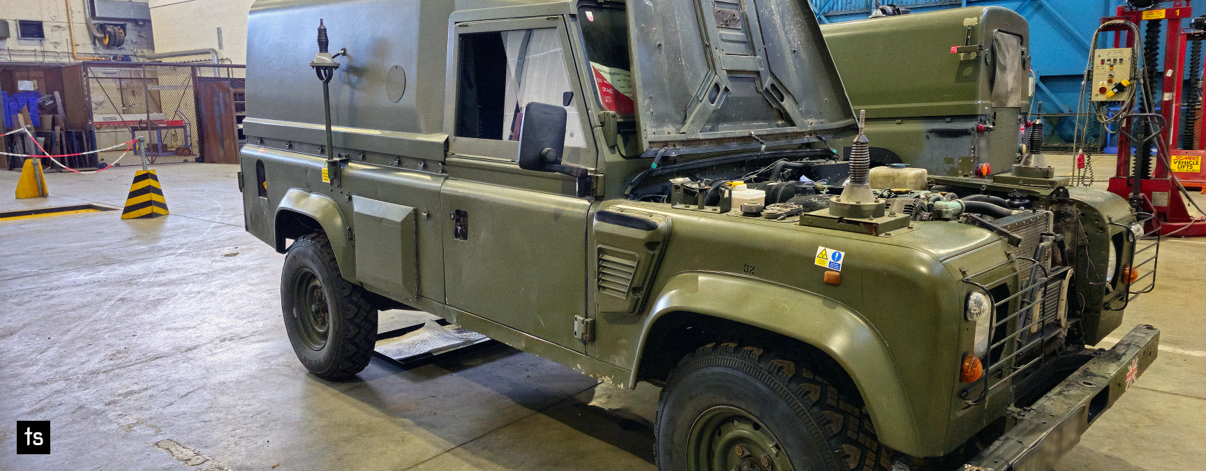 Mechanical engineers working on an Army Land Rover in a workshop