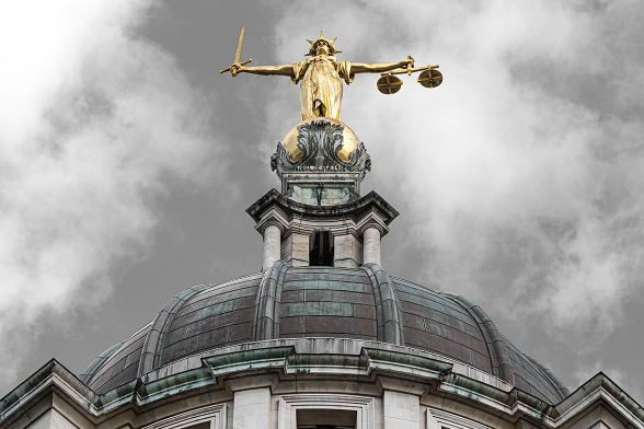 Lady Justice statue atop the Old Bailey in London, holding scales and a sword