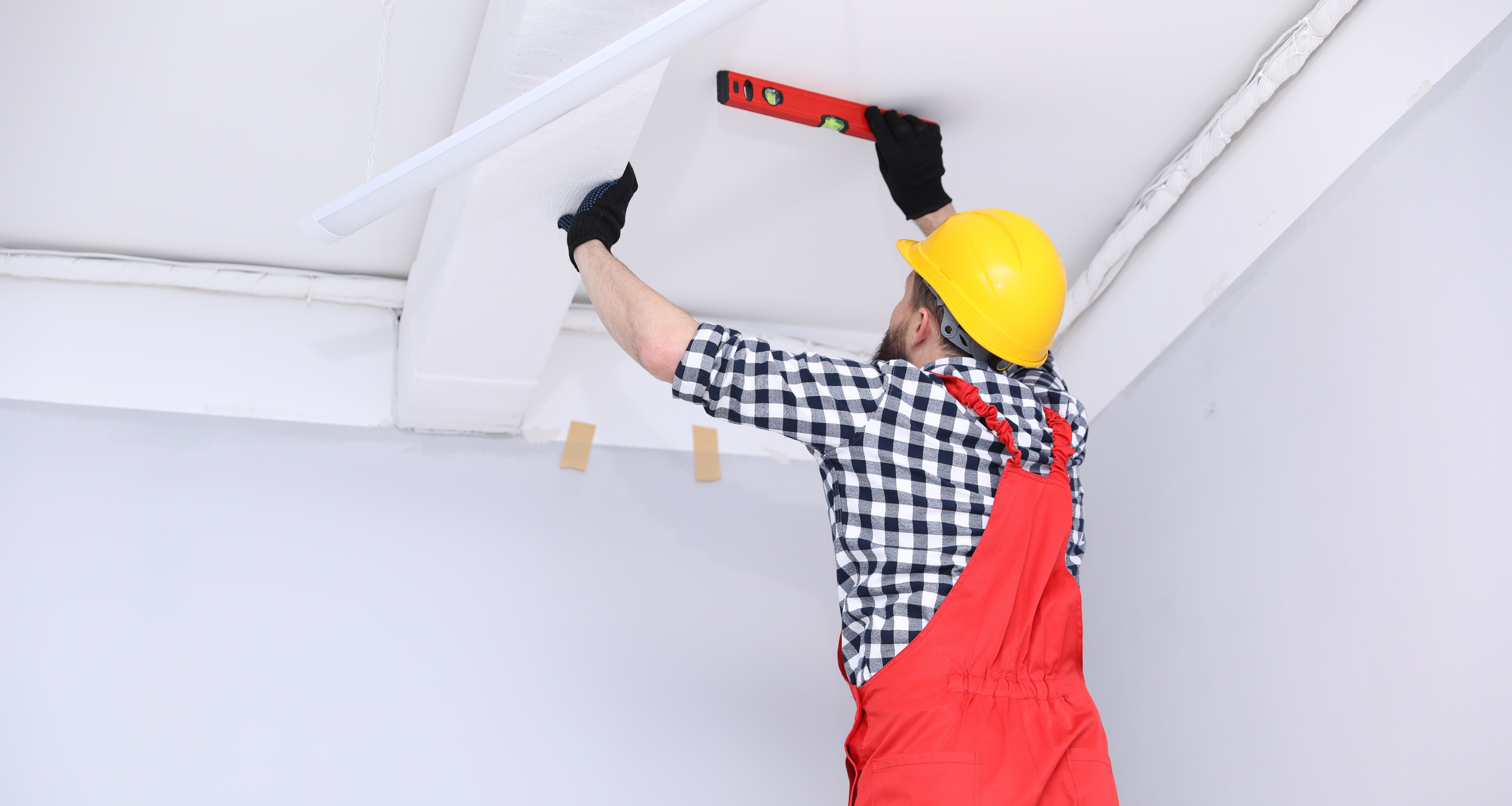 Close-up of a sprinkler system head on the end of a white pipe. A silver metal clamp holds the pipe in place.