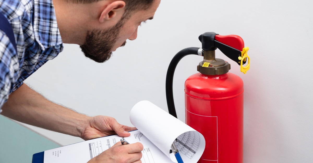 HedrickFireProtection-407717-Man-Examines-Extinguisher-Blogbanner1