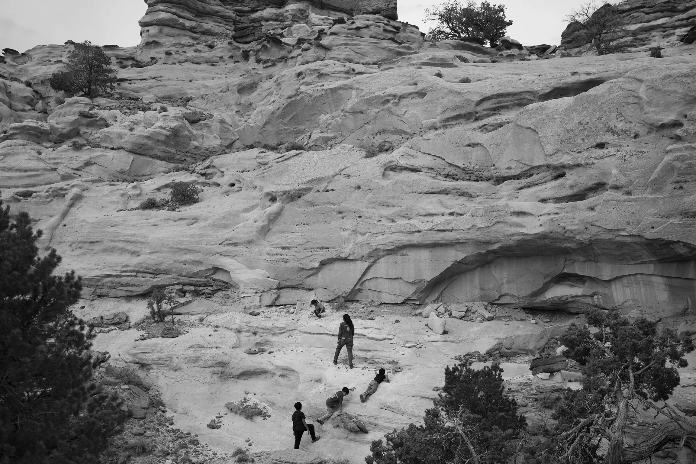 Children climb a large rock formation