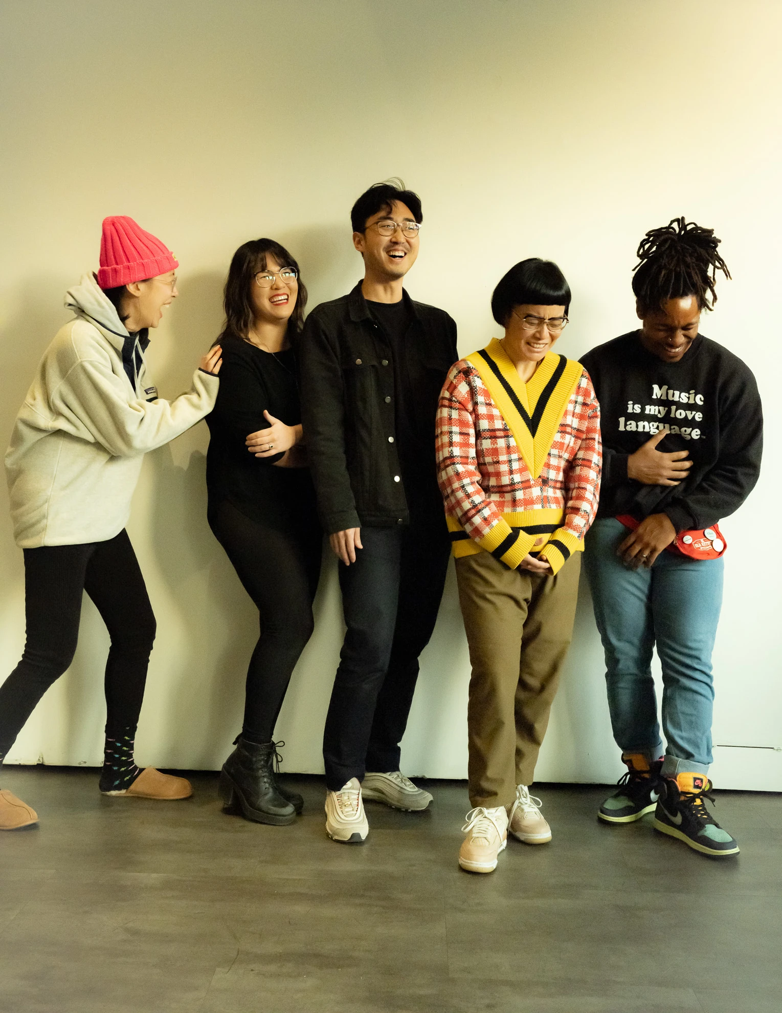 Five people of different genders stand together to post for a photo