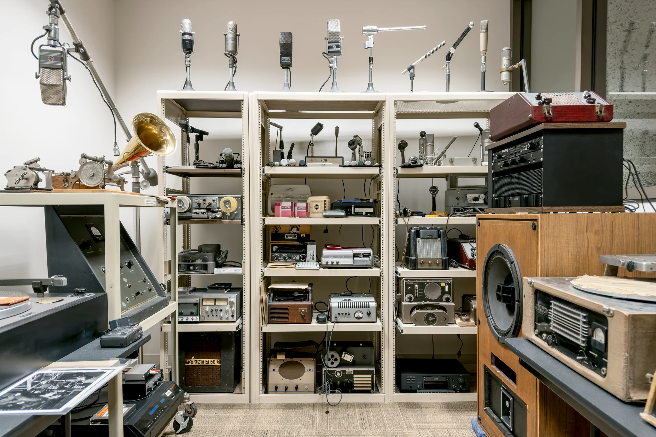 An interior room filled with historical audio equipment stacked on shelves
