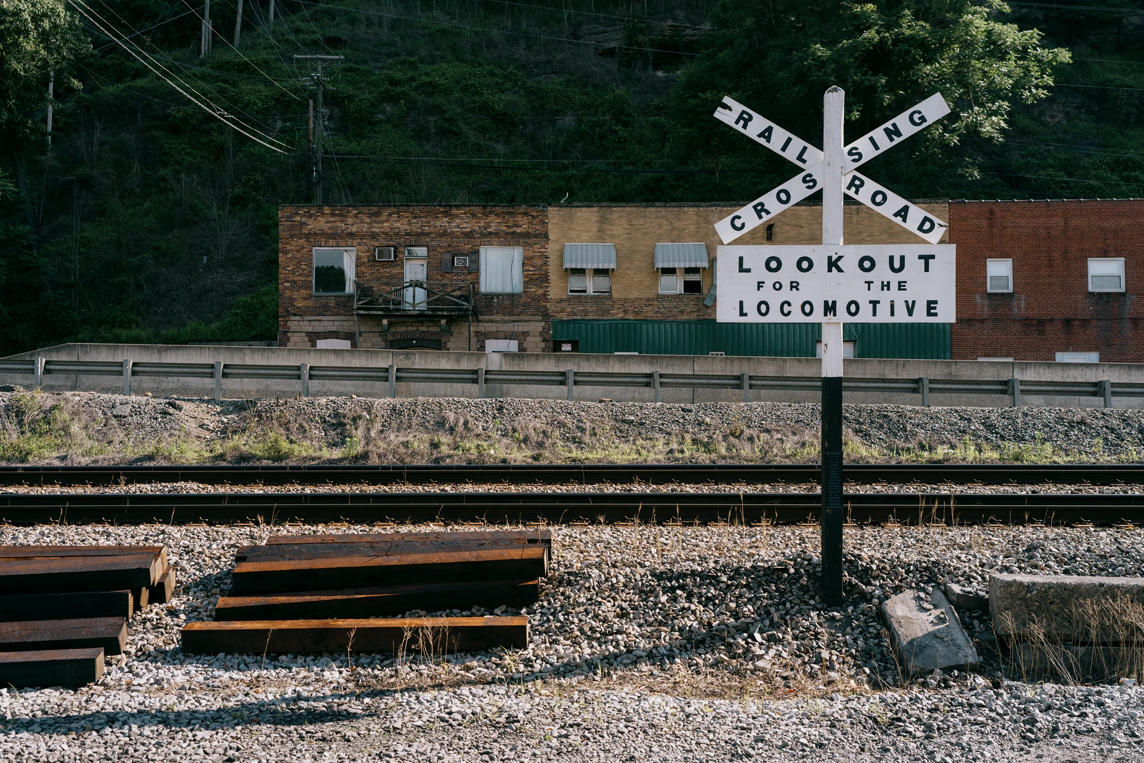 Railroad crossing sign beside train tracks in Matewan, West Virginia.