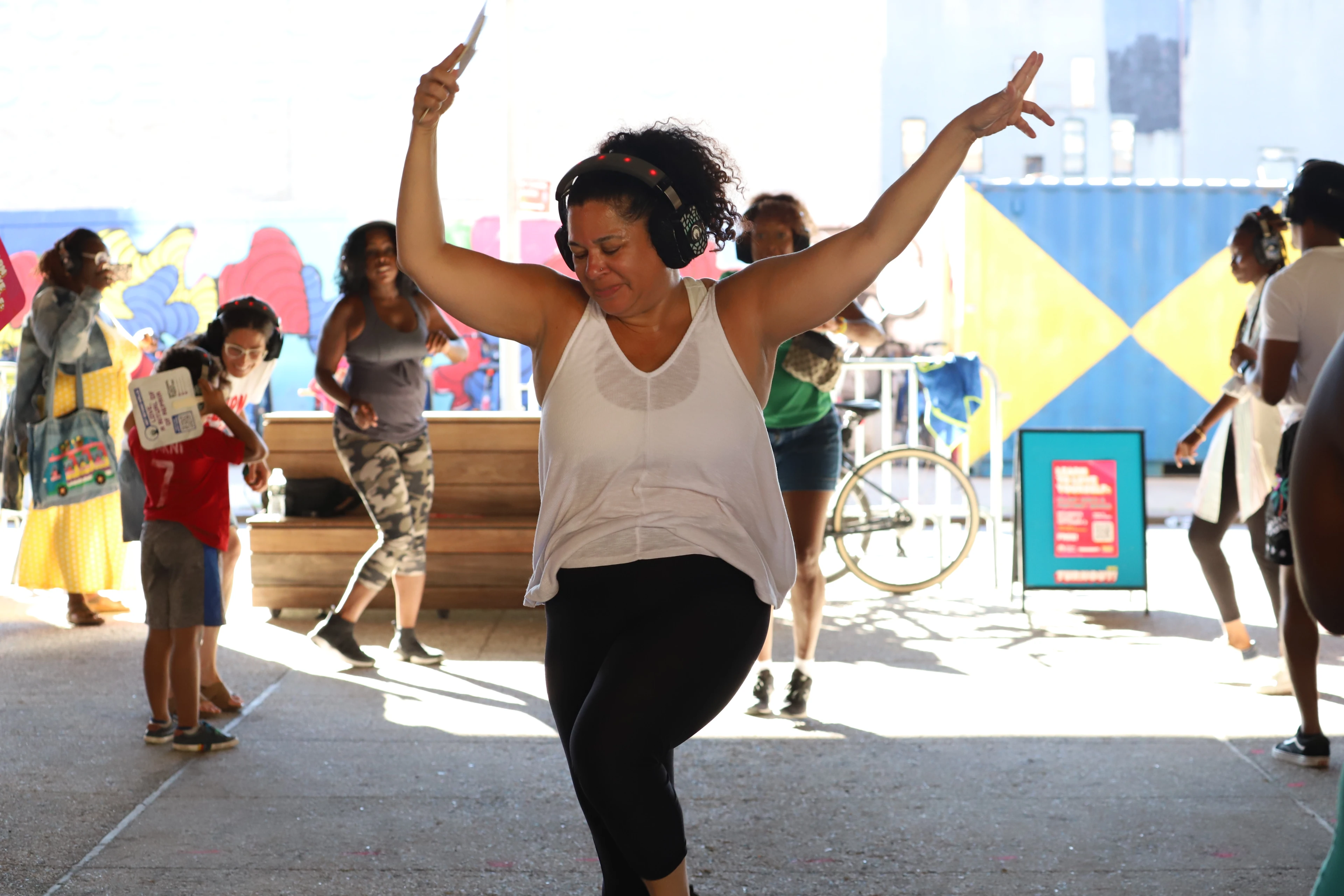 A person raises their arms in dance while they are wearing headphones. 