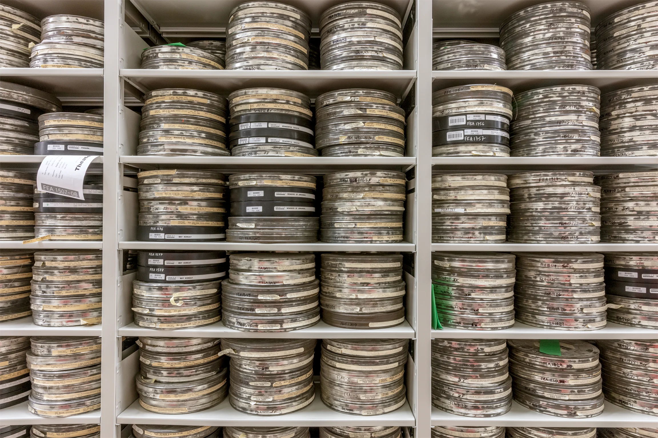 Three tall gray shelves filled top to bottom with film reels