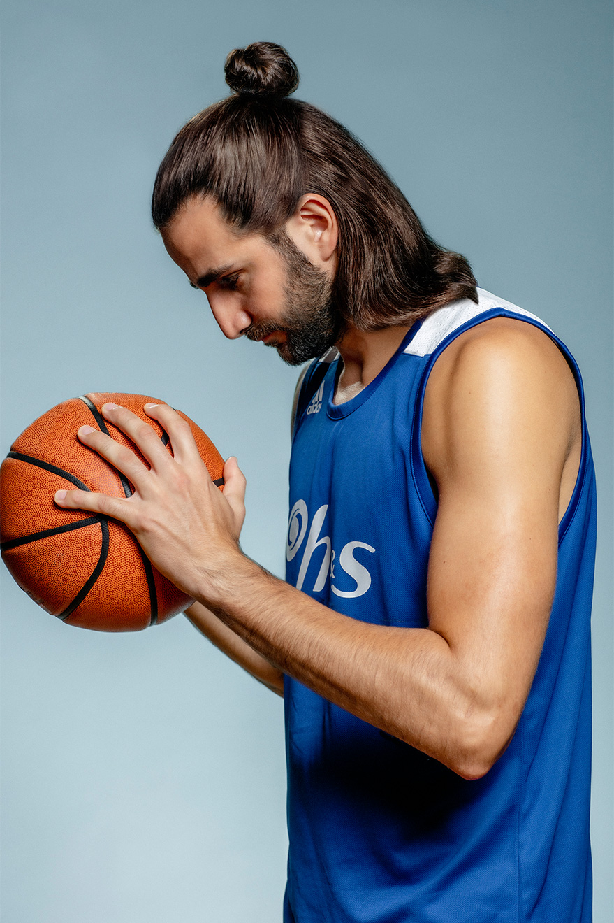 Ricky Rubio, jugador de baloncesto, sosteniendo la pelota y mirándola