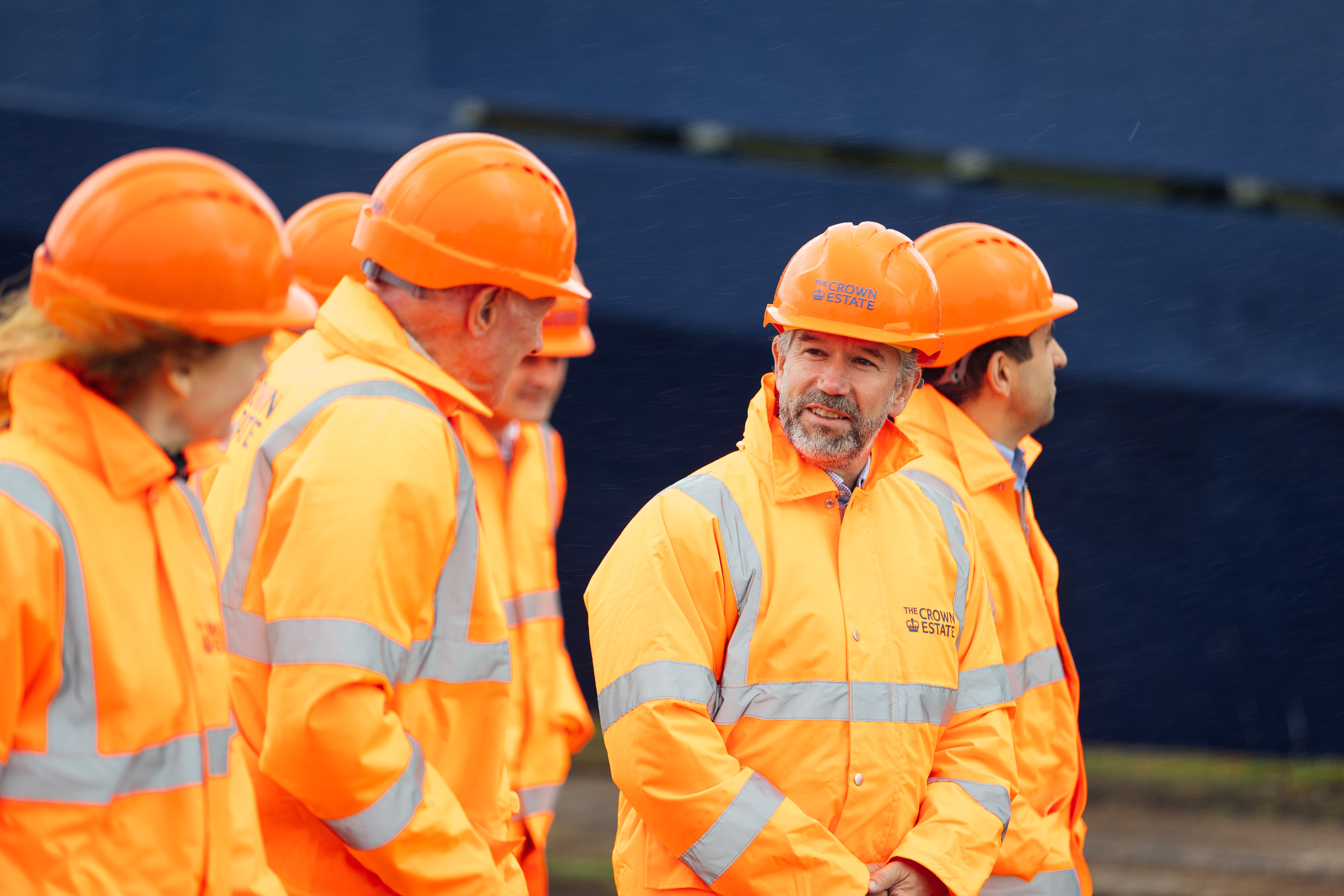 Group of surveyors in orange high viz jackets and hard hats
