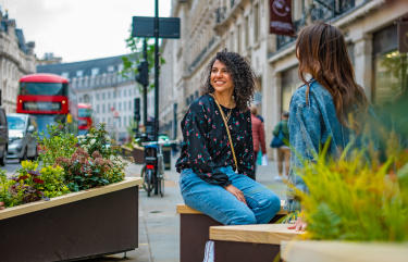 Two people seated by planters in Regent Street