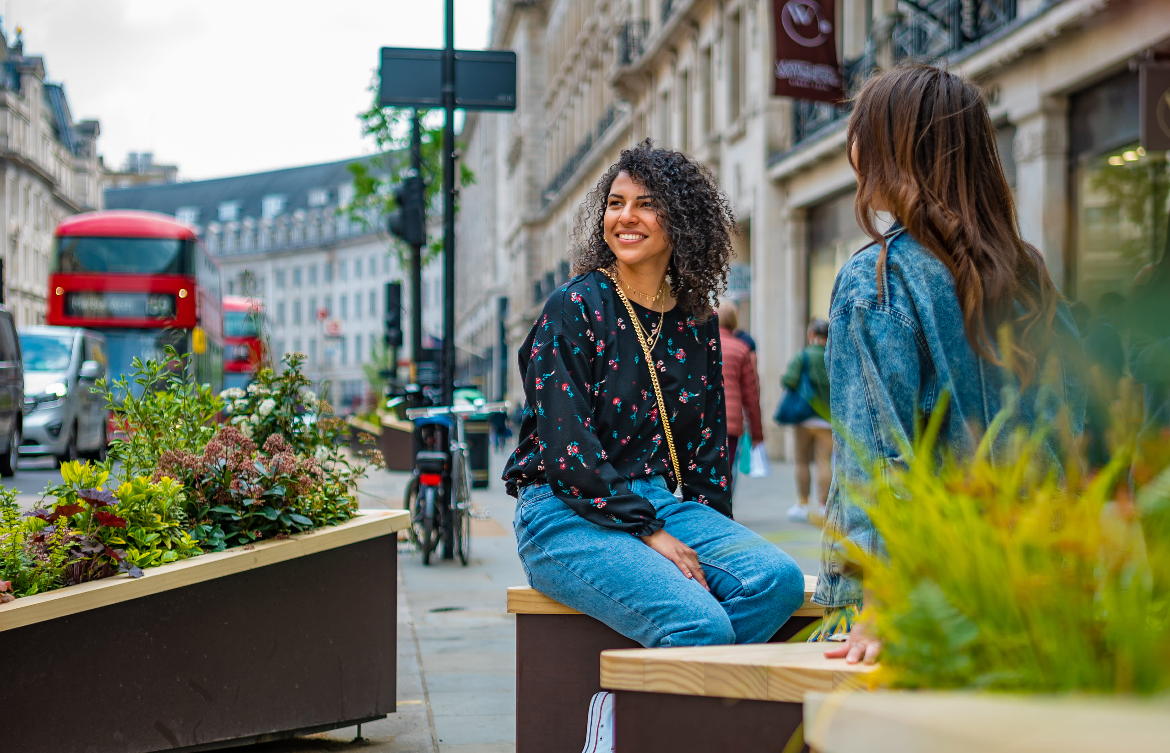 Two people seated by planters in Regent Street