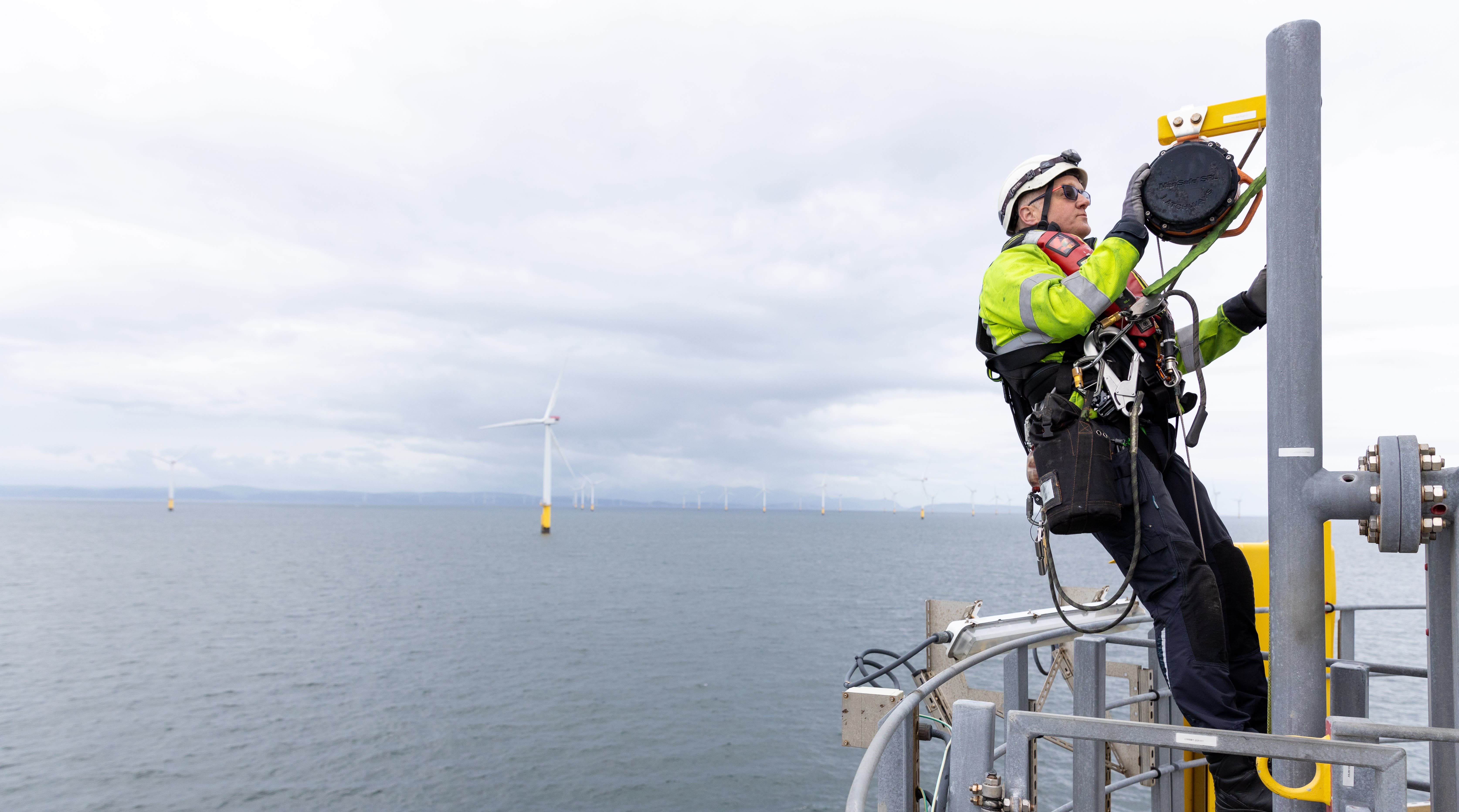 Man in safety harness working on wind turbine