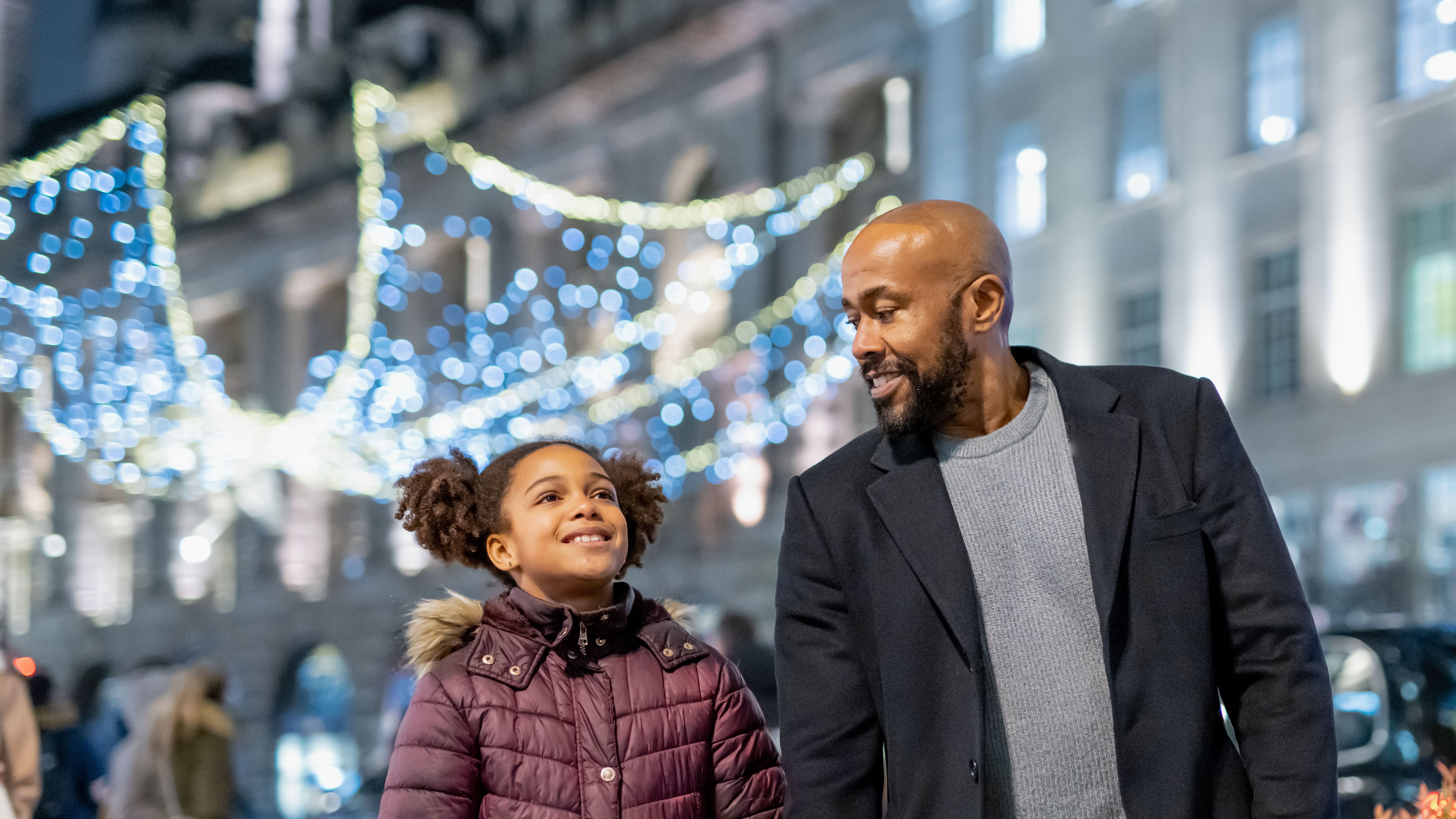 Man and child in Regent Street with Christmas lights in background