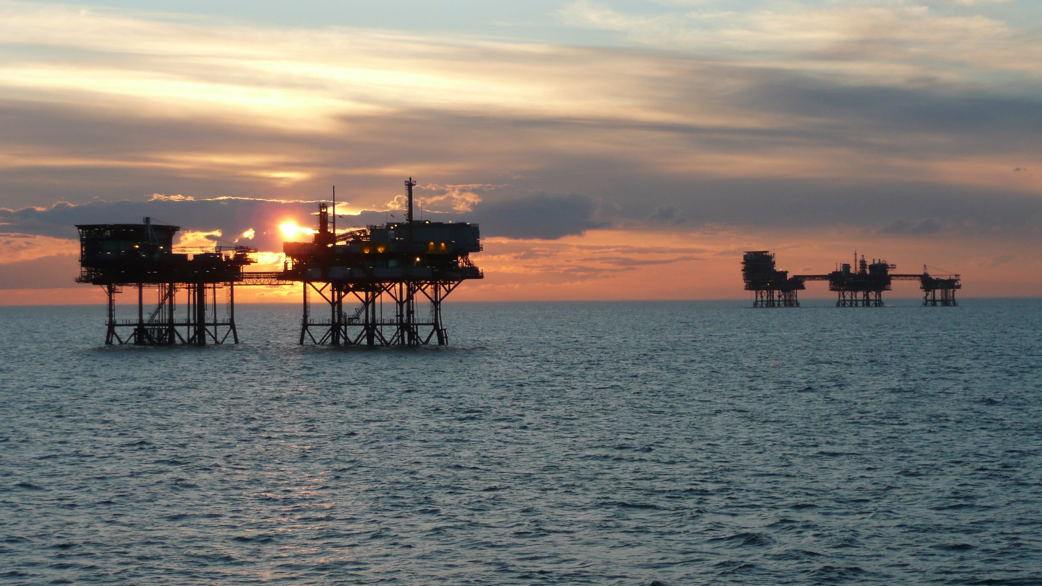 Sea at sunset with rough gas storage structures
