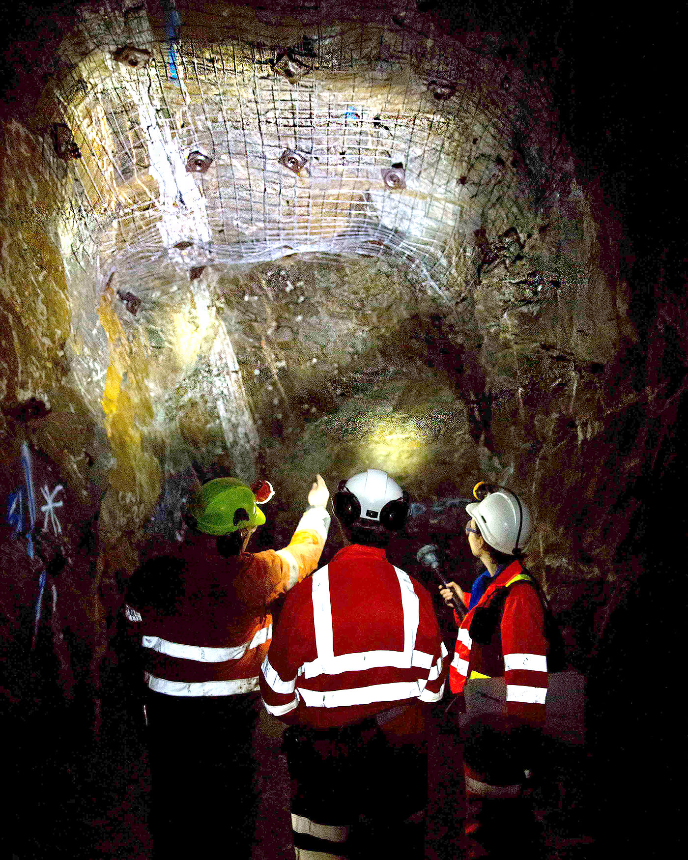 People in high vis jackets and hard hats in a mine