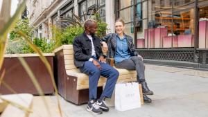 Two people sitting on a bench on Regent Street