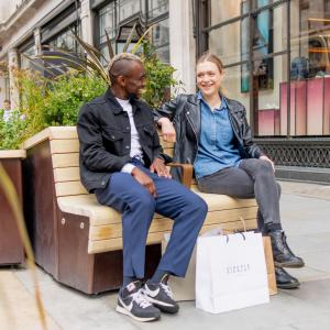 Two people sitting on a bench on Regent Street