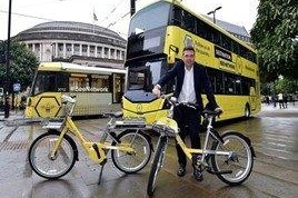 Andy Burnham with Bee Network branded bike, bus and tram