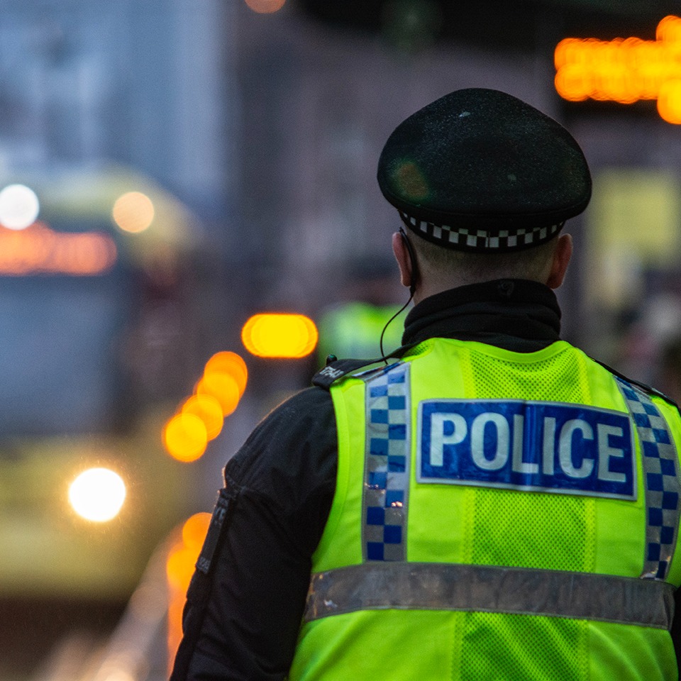 Police officer stood at a metrolink tram stop in Manchester