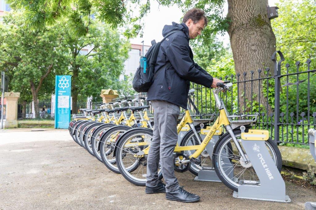 A man docking a bike in a cycle hire dock
