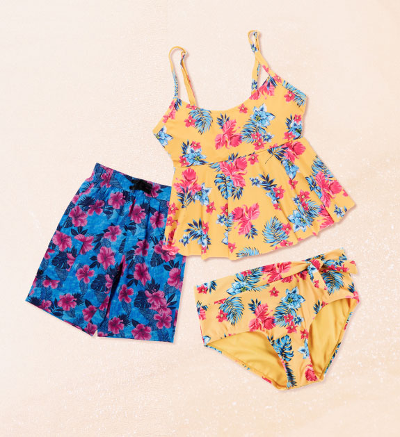 Pair of blue swim trunks with pink flowers. Yellow floral tankini top an matching bottoms.