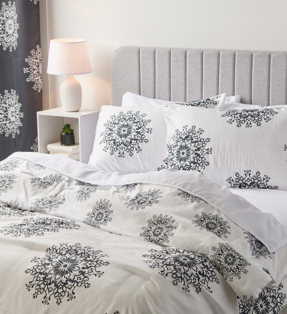 White comforter set with black mandala effect design.
