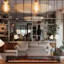 A warm and inviting lounge area with comfortable sofas, plants, and soft lighting, featuring a modern fireplace.