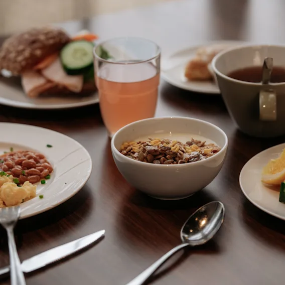 En god och varierad hotellfrukost serverad på ett mörkt träbord.