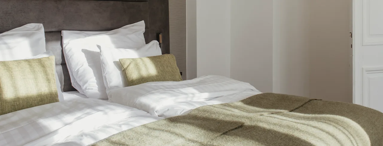 Inviting Strawberry Hotels room with green blanket and living area - quality at fair price